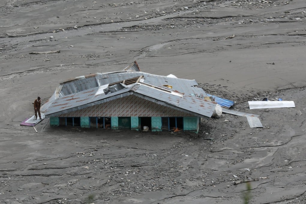 A man looks at a mud-covered house after a cloudburst in Uttarakhand, India, on Monday. Photo: EPA