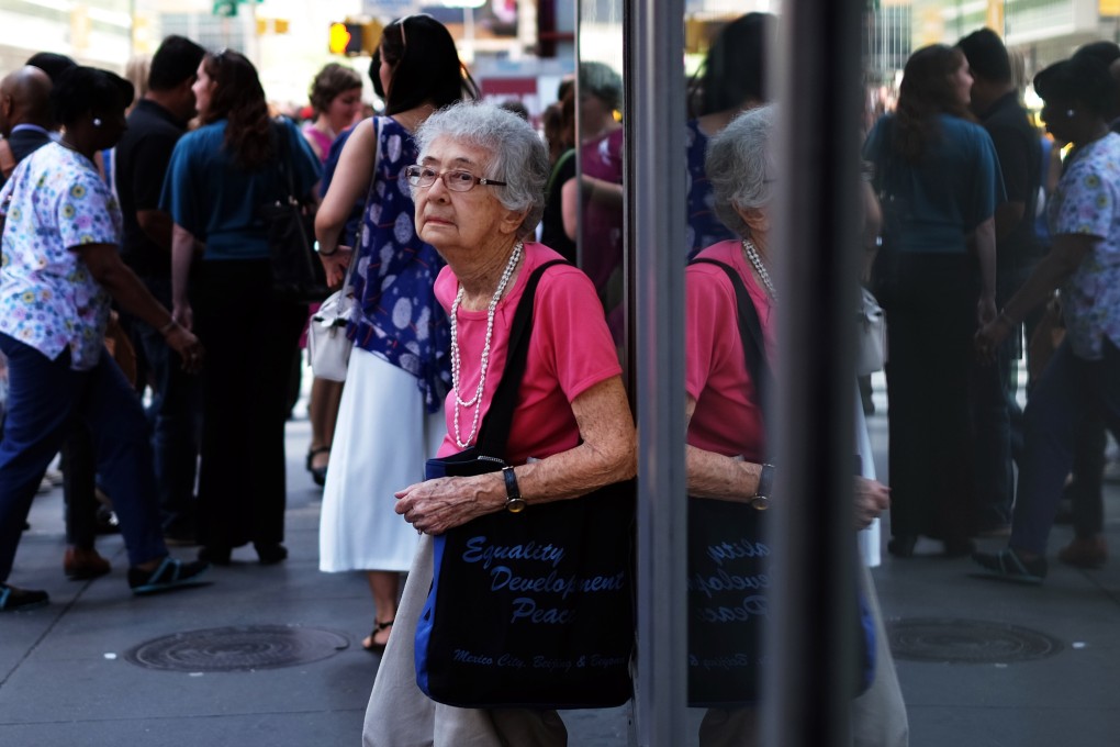 An elderly woman rests leans against a shop window in New York on June 25, 2015. Photo: AFP