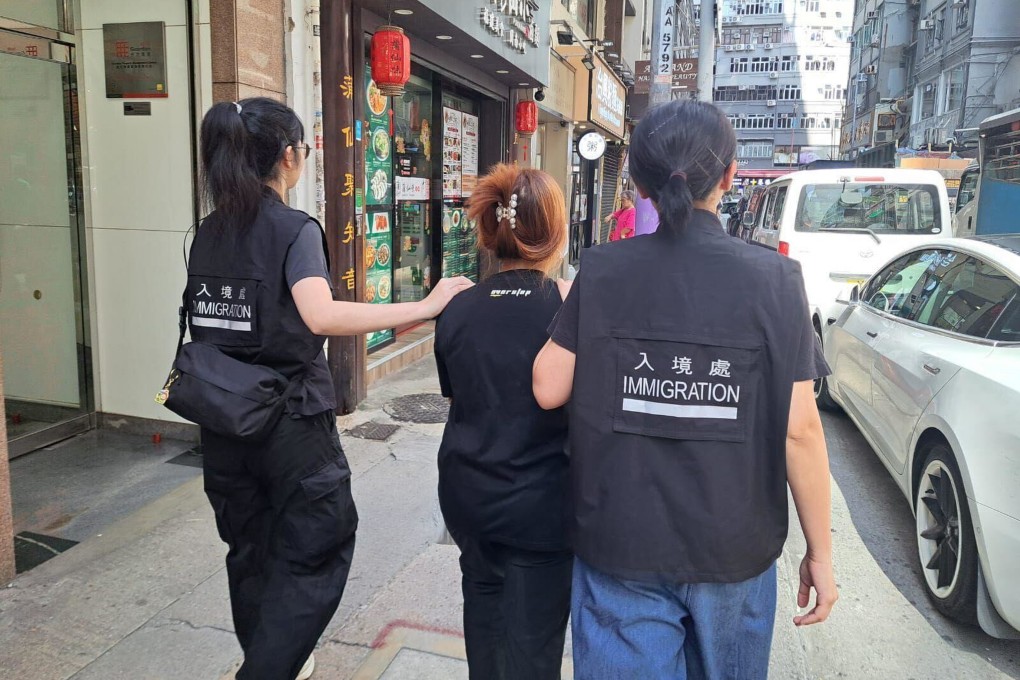 Immigration Department staff take away a suspect. Photo: Handout