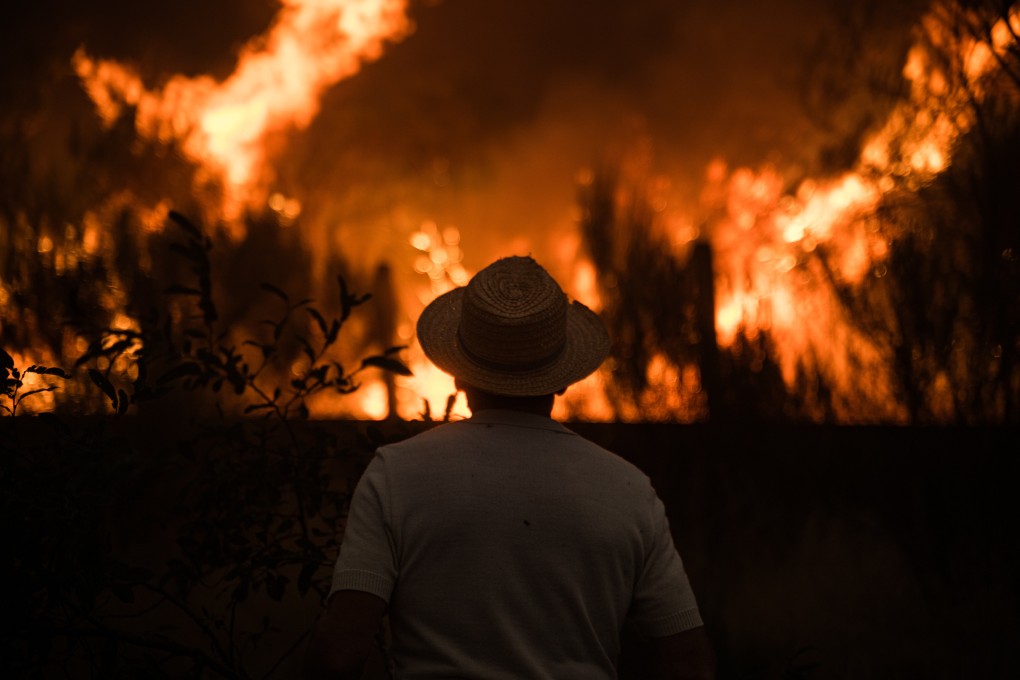 A resident watches as a wildfire spreads in Galicia, Spain, on Saturday. Photo: dpa