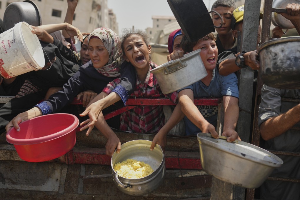 Palestinians struggle to get donated food at a community kitchen in Gaza City on August 16. Photo: AP