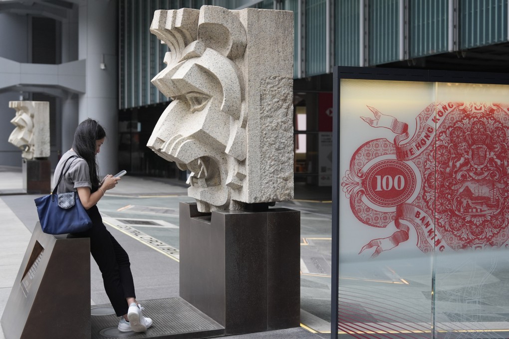 A woman sits outside HSBC’s main building in Central, on July 30. Photo: Eugene Lee