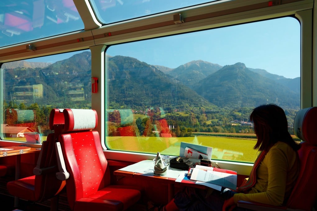 A passenger on the Glacier Express train enjoys a view of the Swiss countryside. A train journey tends to be more comfortable and better for the environment than a flight, although it is slower and can even sometimes be more expensive. Photo: Shutterstock