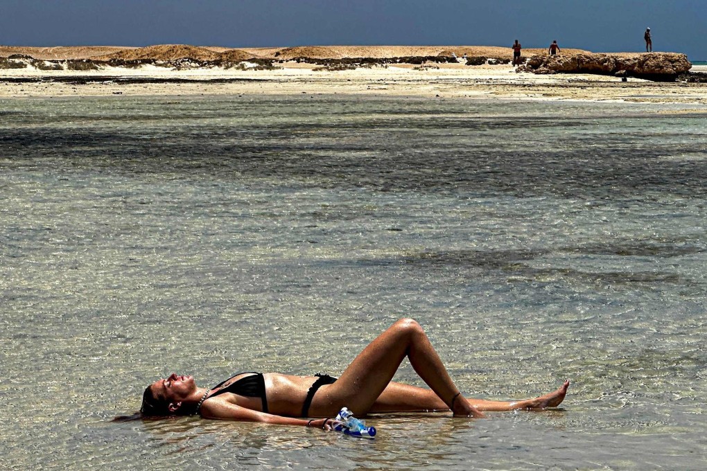 A tourist lies in the shallow waters of the Ras Hankorab beach in Egypt’s Red Sea Wadi Al-Gemal protectorate  on May 28. Photo: AFP