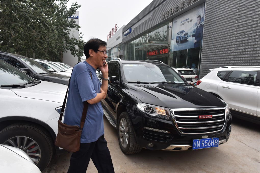 A man walks past Haval brand SUVs made by Great Wall Motor, outside a showroom in Beijing on August 22, 2017. Photo: AFP