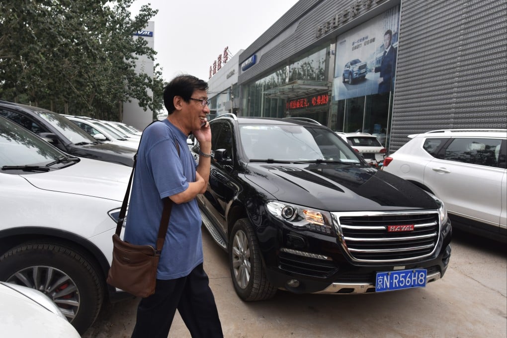 A man walks past Haval brand SUVs made by Great Wall Motor, outside a showroom in Beijing on August 22, 2017. Photo: AFP