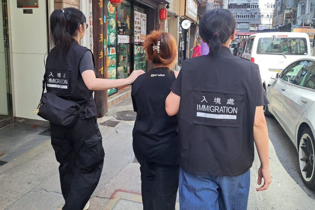 Immigration Department officers take away a person suspected of links to an illegal ride-hailing syndicate on August 17. Photo: Handout