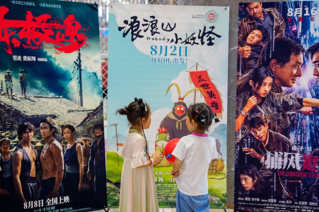 Children stand in front of a film poster for Nobody, which has become a box office smash in China. Photo: Xinhua
