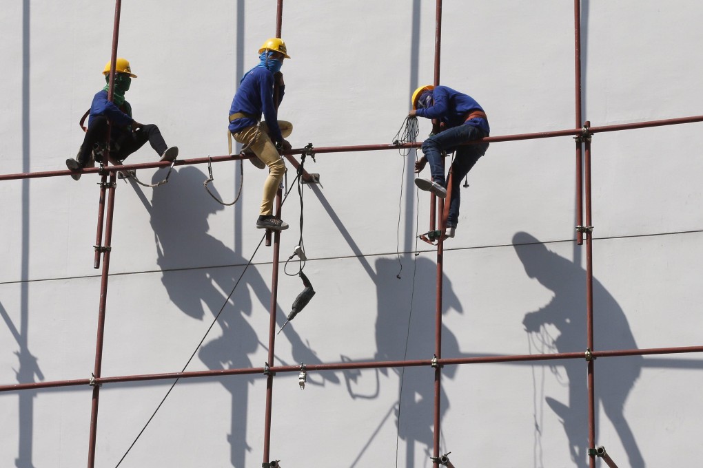 Thai workers on scaffolding at a building site in Bangkok. Thailand’s ageing population and shrinking workforce have forced it to rely on at least 3 million registered foreign labourers. Photo: EPA