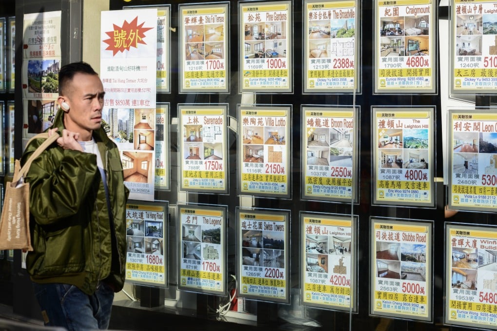Pedestrians walk past a real estate agency in Causeway Bay, Hong Kong. Photo: Antony Dickson