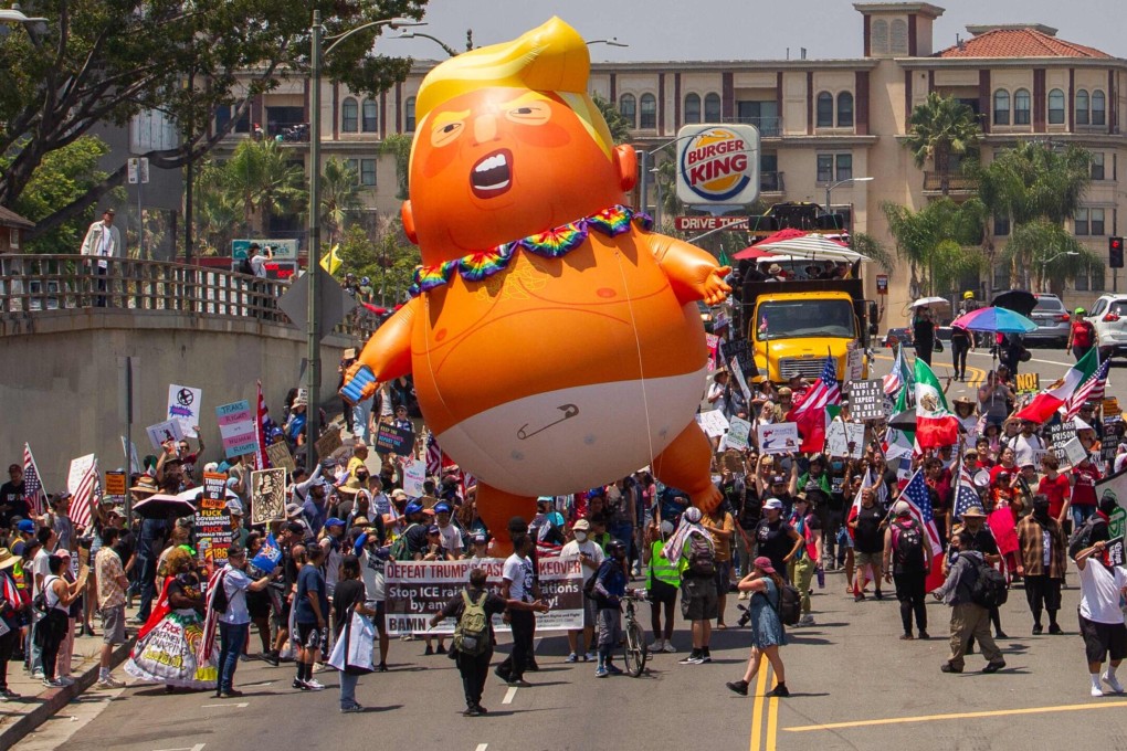 Anti-Trump protesters holding a Trump balloon march in Los Angeles, California, on August 2. Photo: Getty Images via AFP