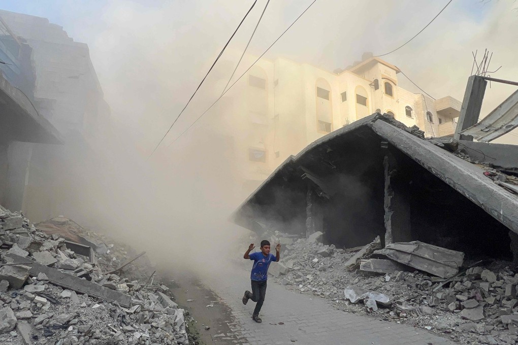 A Palestinian boy rushes away from the site of Israeli air strikes on a building in the Saftawi neighbourhood west of Jabalia in the northern Gaza Strip on August 19. Photo: AFP