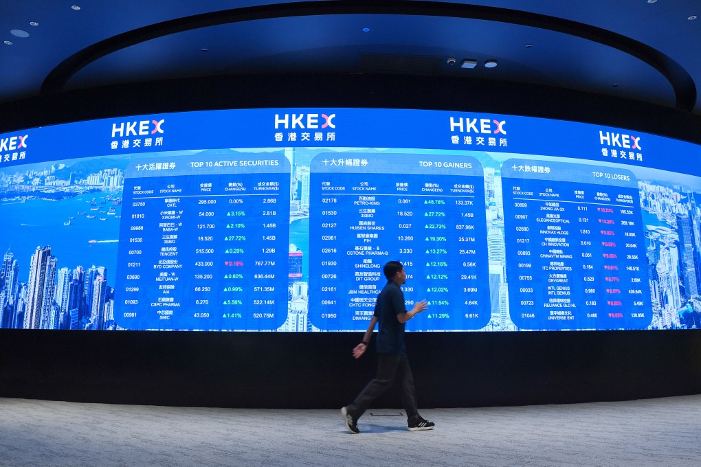 A man walks past an electronic display board at the Hong Kong stock exchange on May 20, 2025. Photo: Xinhua