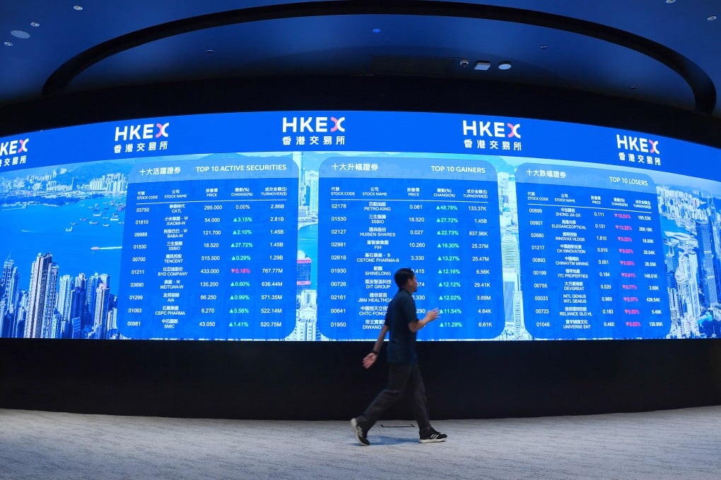 A man walks past an electronic display board at the Hong Kong stock exchange on May 20, 2025. Photo: Xinhua