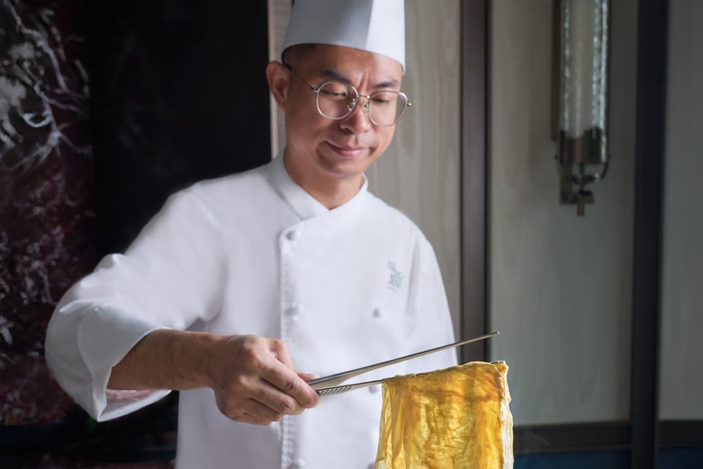 Chef Albert Li lifts up freshly made beancurd skin specially created from Hei Long Jiang soybeans at Jin Ting Wan at Singapore’s Marina Bay Sands, where he is reimagining Cantonese cuisine while honouring its techniques and ingredients. Photo: Jin Ting Wan