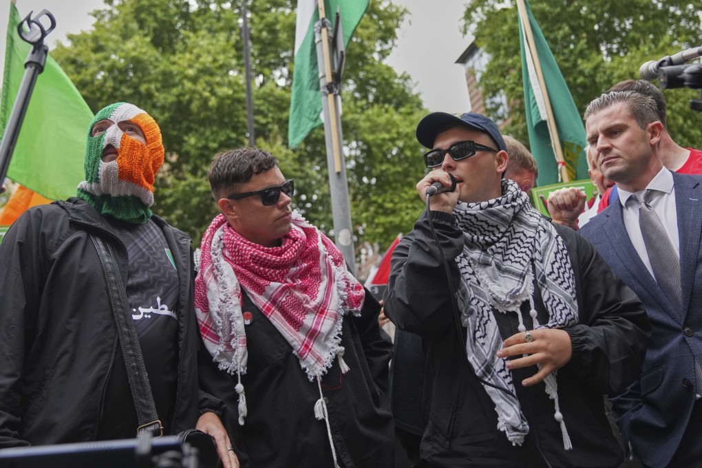 Kneecap member Liam Og O hAnnaidh, also known as Mo Chara (second right), speaks to supporters as he departs Westminster Magistrates’ Court in London on Wednesday. Photo: AP