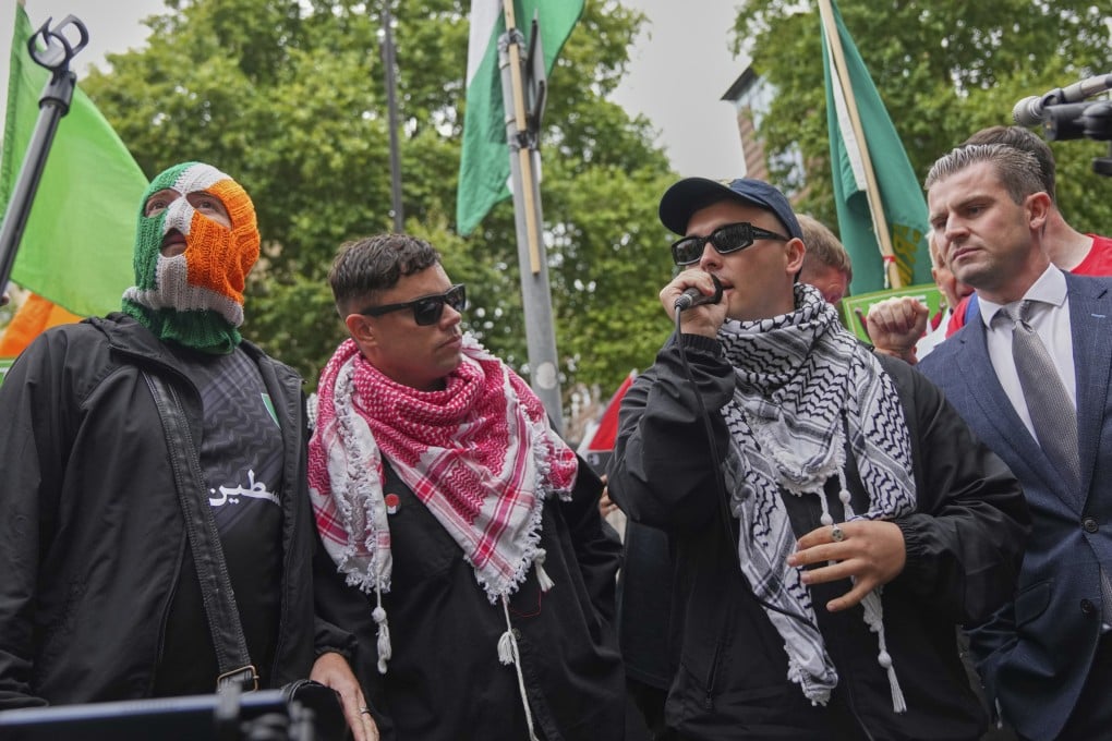 Kneecap member Liam Og O hAnnaidh, also known as Mo Chara (second right), speaks to supporters as he departs Westminster Magistrates’ Court in London on Wednesday. Photo: AP