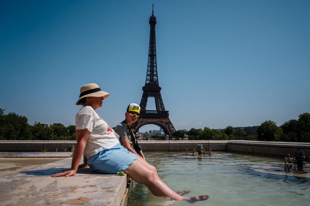 Tourists cool off in the Trocadero Fountain, in front of the Eiffel Tower in Paris, last month as temperatures approached 40 degrees Celsius (104 degrees Fahrenheit). Photo: AFP