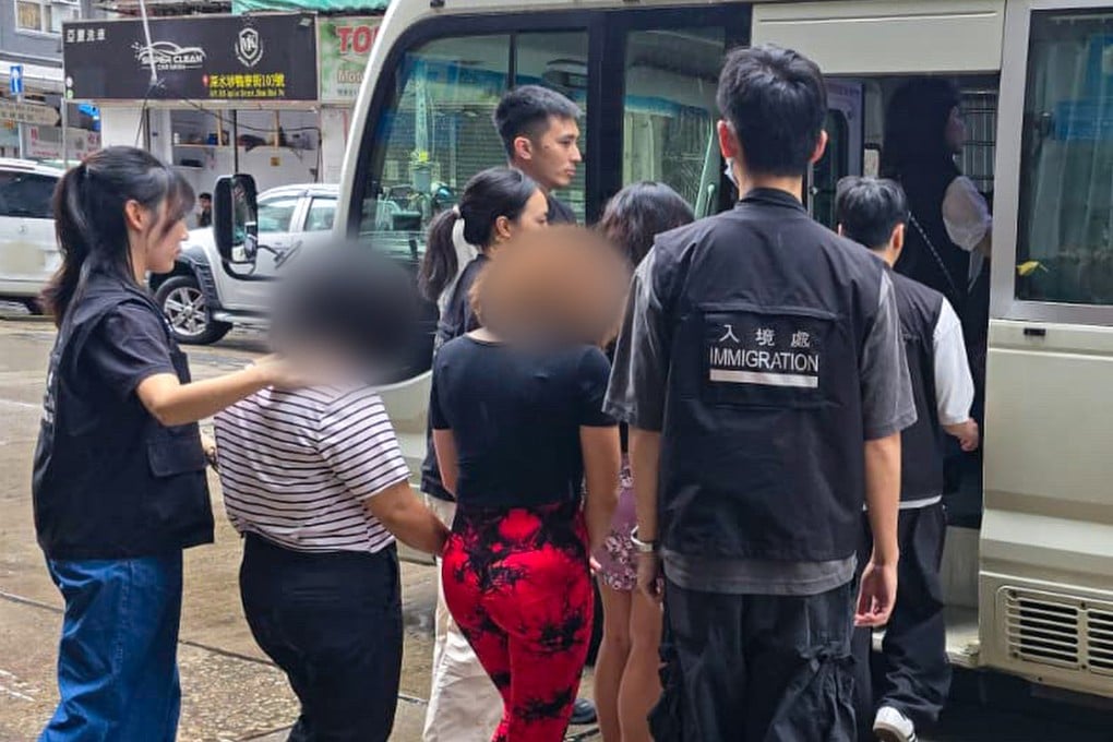 Filipino domestic workers caught operating an illegal dental clinic in a Hong Kong tenement building are loaded into a van last Sunday. Photo: Handout