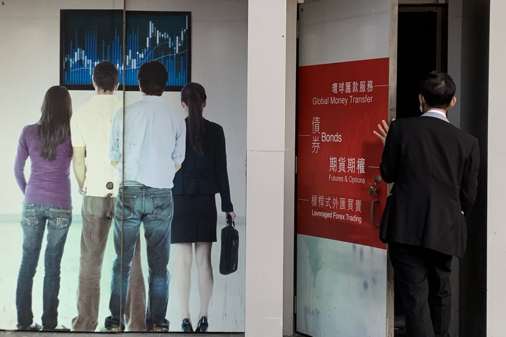A security guard opens a door adjacent to an advertising billboard at a securities firm in Mong Kok on January 26, 2021. Photo: Nora Tam