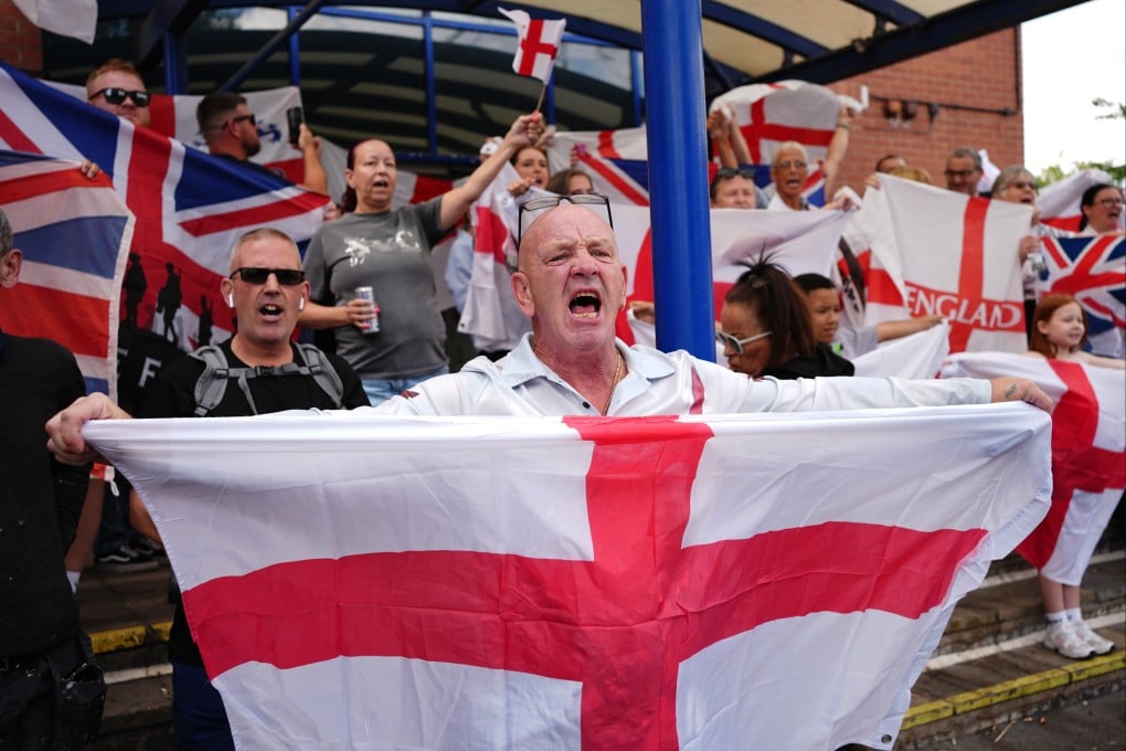People protest under the Abolish Asylum System slogan outside the Castle Bromwich Holiday Inn in Birmingham, England, UK on Sunday. Photo: PA Wire / dpa