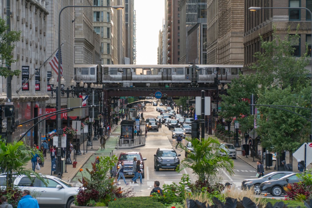 A busy street in downtown Chicago as a train passes along overhead tracks during morning rush hour traffic. Photo: Shutterstock