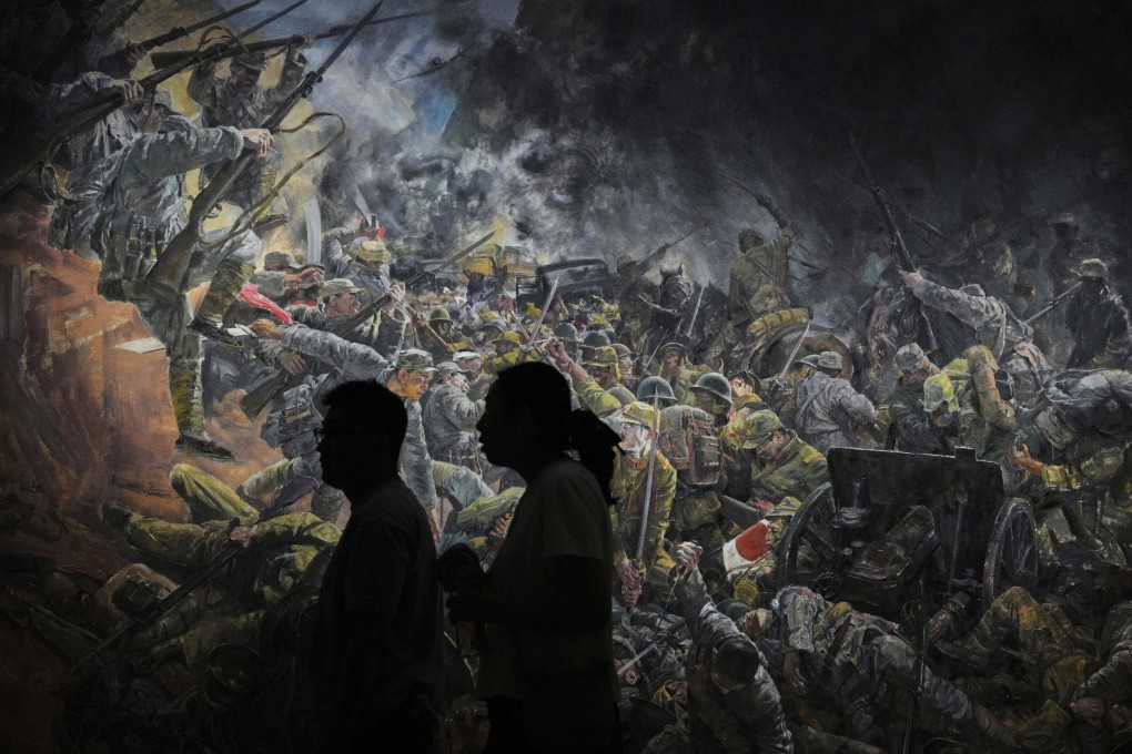 Visitors to the National Art Museum of China in Beijing examine a painting commemorating the wartime struggle against Japan. Photo: AP Photo/Andy Wong
