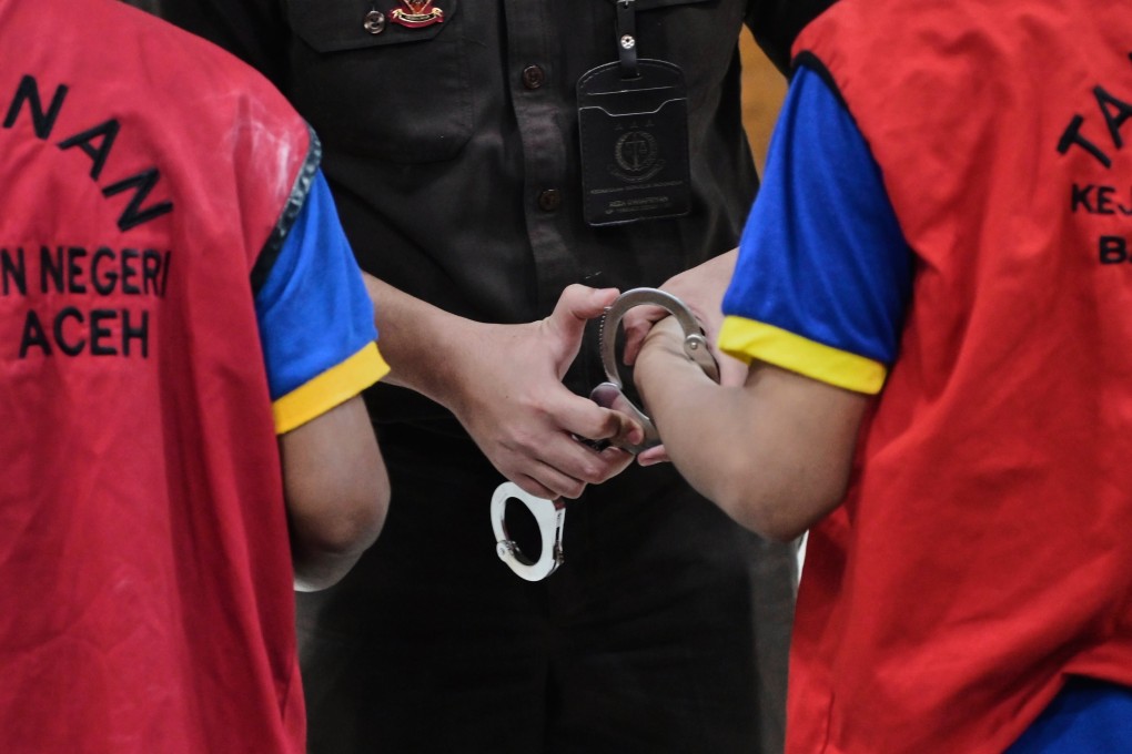 A prosecutor puts a handcuff on two men accused of having gay sex, after their sentencing hearing at a Sharia Court in Banda Aceh, Indonesia earlier this month. Photo: AP