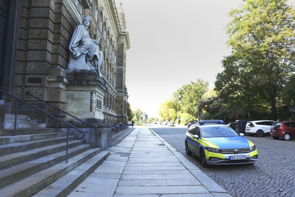 A police car is parked in front of the prosecution building in Dresden, Germany on Tuesday after an American was injured in a knife attack. Photo: dpa via AP