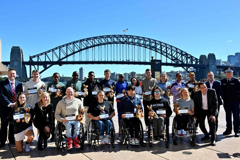 Elite marathon runners pose for photos in front of the Sydney Harbour Bridge. Photo: AFP