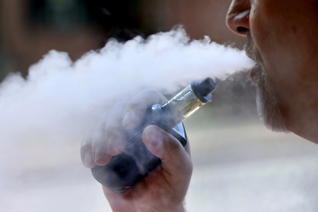 A man exhales while smoking an e-cigarette. Photo: AP