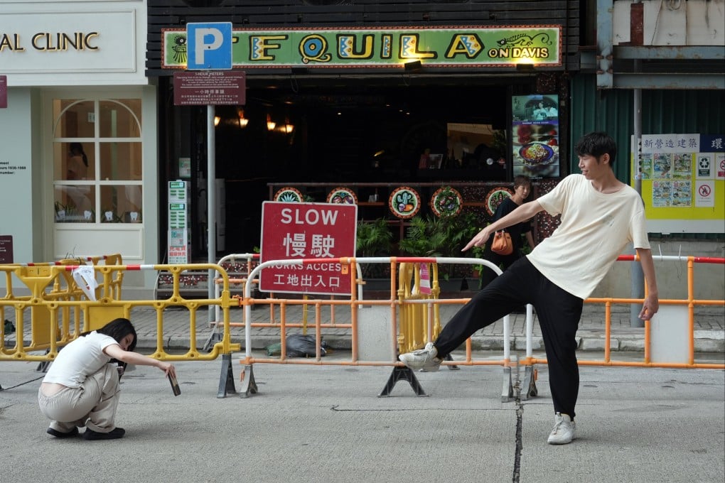 A tourist strikes a pose on a carriageway in Kennedy Town on June 16. Photo: Eugene Lee