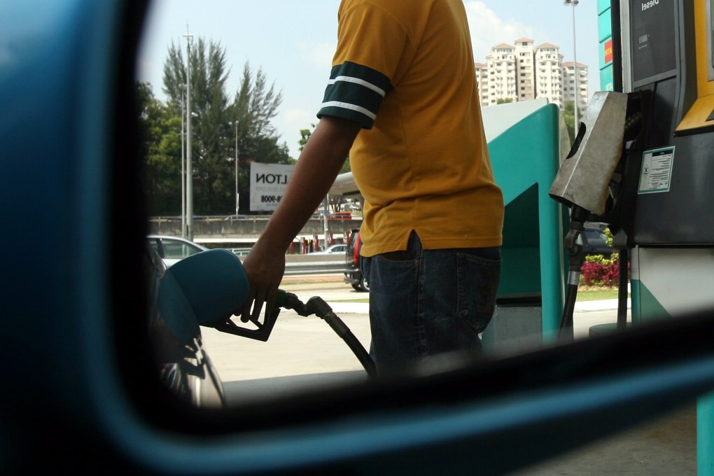 A man fills up a car with fuel at a petrol station in Kuala Lumpur. Photo: AFP