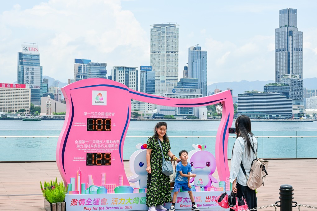 Tourists have their picture taken in front of a countdown display for the National Games in Hong Kong on August 1. Photo: Xinhua