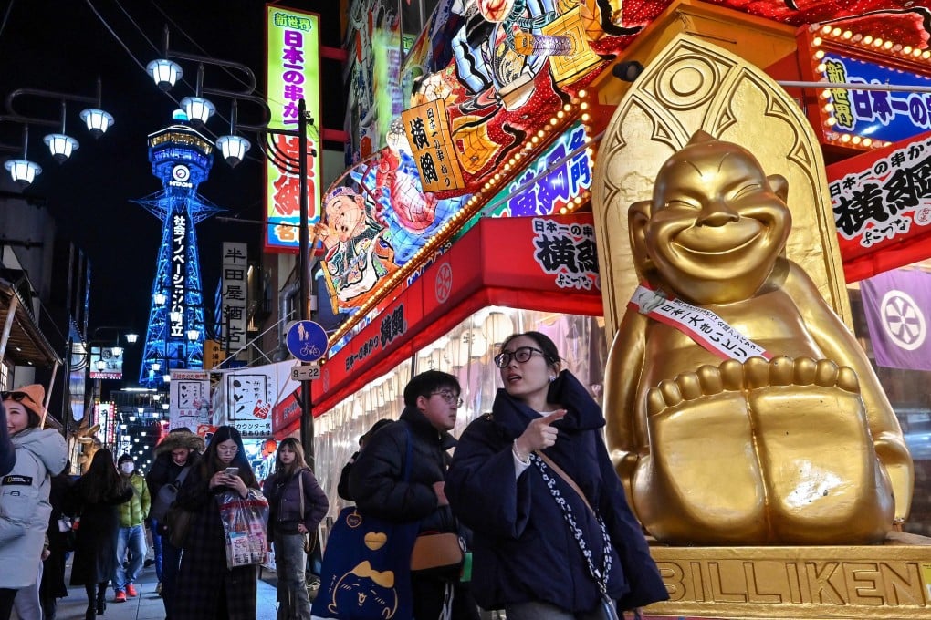 Tourists walk past shops and restaurants in the popular Shinsekai district of Osaka, with the Tsutenkaku Tower in the background, in February. Photo: AFP