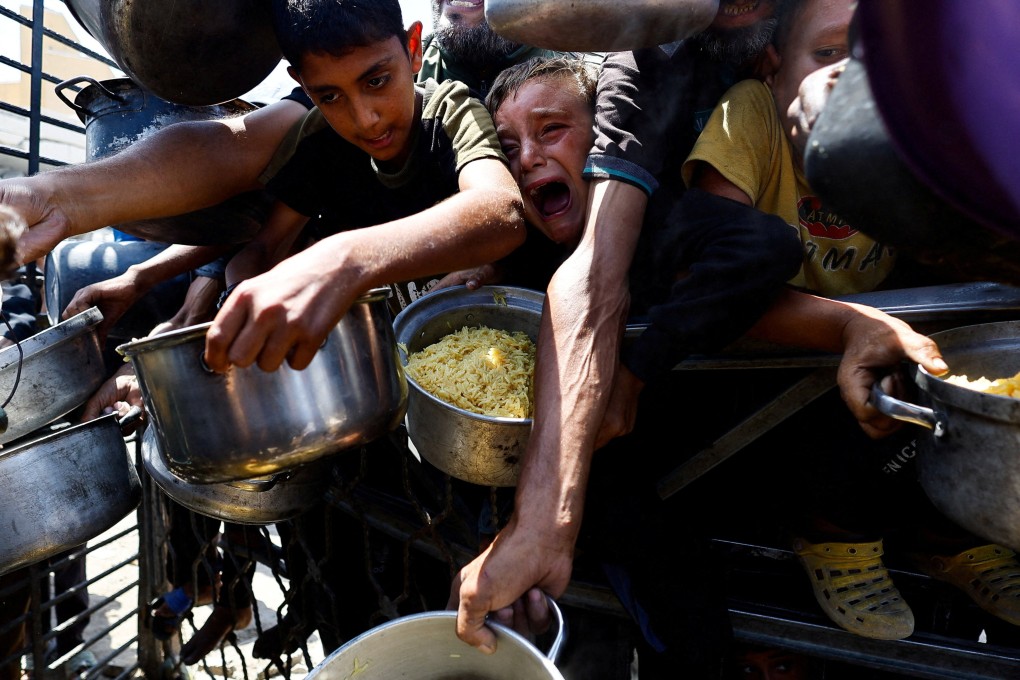 Palestinians wait to receive food from a charity kitchen in Gaza City. Photo: Reuters