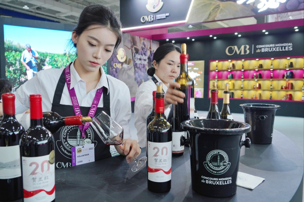 Volunteers serve wine, produced at the eastern foot of China’s Helan Mountain, at an event in June. Photo: Xinhua