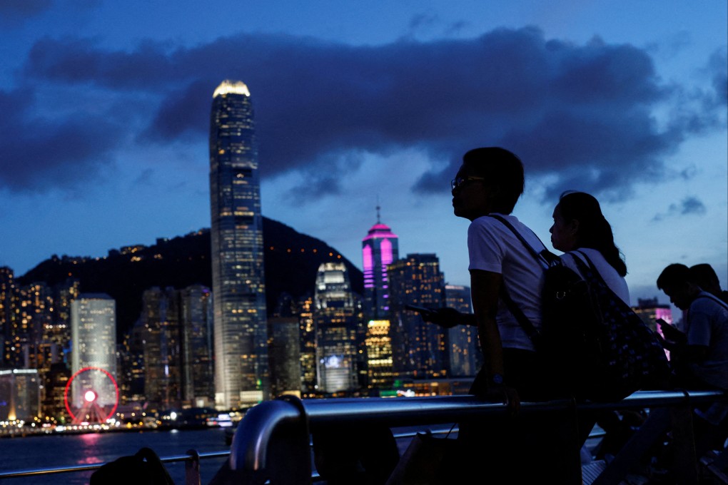 Tourists look across Victoria Harbour. Photo: Reuters