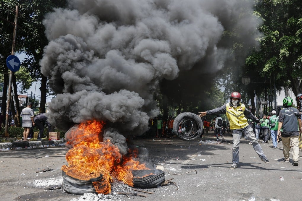 A protester burns tyres after clashing with police in Jakarta on Friday. Photo: EPA