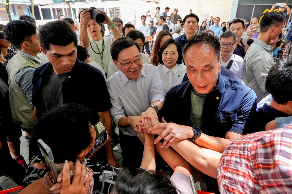 Chief Executive John Lee (centre) interacts with children and residents at Shau Kei Wan’s Oi Tung Estate. Photo: Elson Li