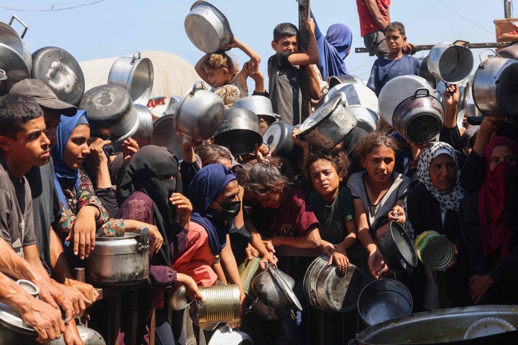 Palestinian women and children wait to receive food from a charity kitchen in Khan Yunis in the southern Gaza Strip on Wednesday. Photo: AFP
