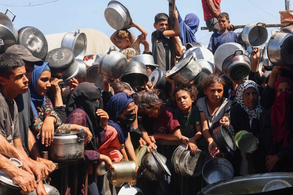 Palestinian women and children wait to receive food from a charity kitchen in Khan Yunis in the southern Gaza Strip on Wednesday. Photo: AFP