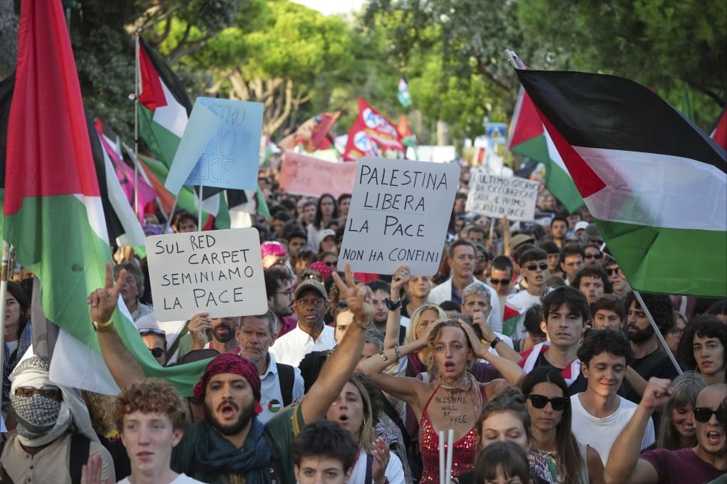Demonstrators hold placards that read “On the red carpet lets sow peace” and “Free Palestine, peace has no borders” during a march in support of the Palestinian people in Gaza, during the Venice Film Festival in Italy on Saturday. Photo: Invision/AP