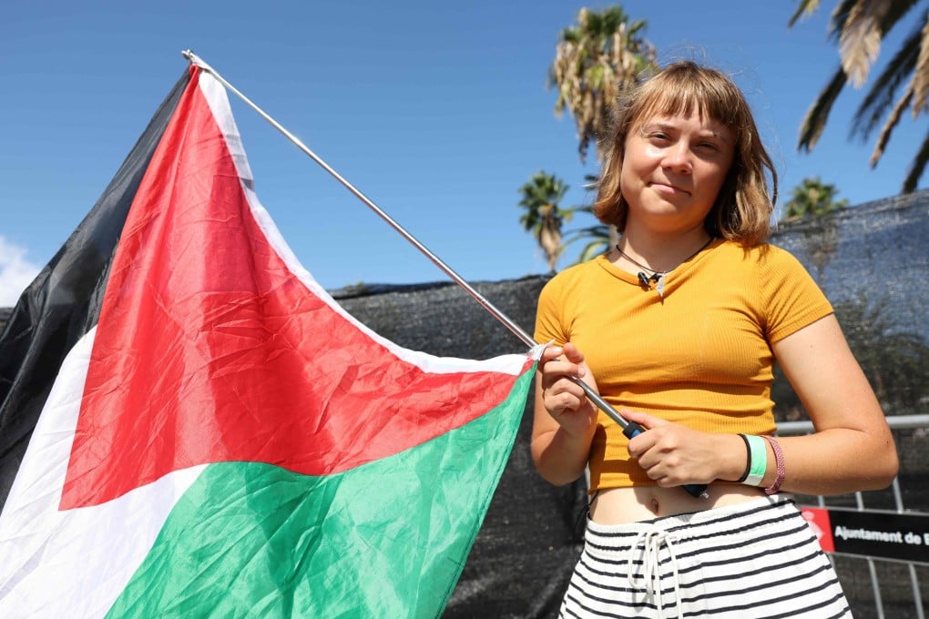 Swedish climate activist Greta Thunberg poses with a Palestinian flag as a flotilla carrying humanitarian aid and activists prepares to leave for Gaza, in Barcelona, Spain, on Saturday. Photo: AFP