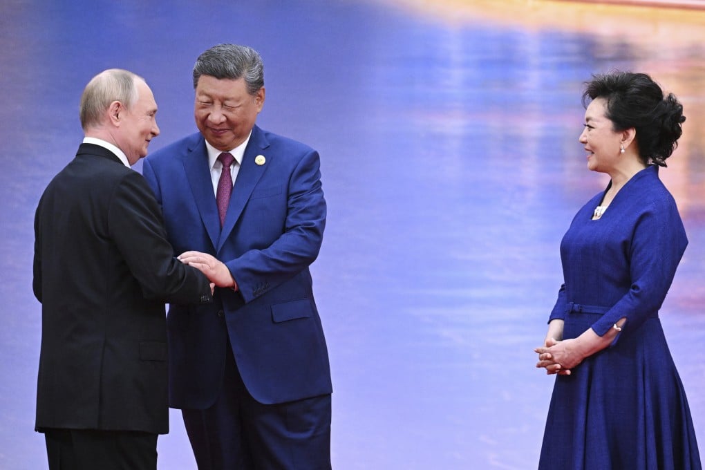 Chinese President Xi Jinping greets Russian leader Vladimir Putin with a two-handed handshake as first lady Peng Liyuan looks on, in Tianjin on August 31. Photo: Pool via AP