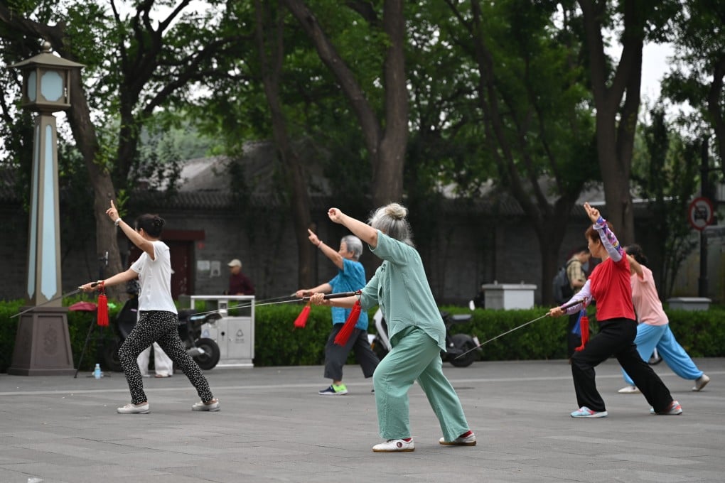 Chinese pensioners practise tai chi with swords in a Beijing square. Photo: dpa