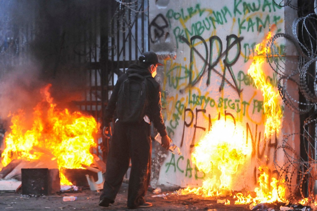 A protester sets fire to the gate of the regional parliament building in Bandung, Indonesia, on Monday. Photo: Reuters