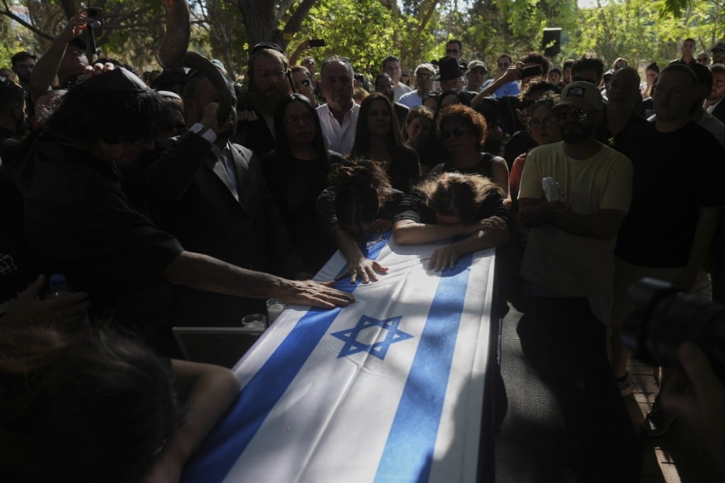 Friends and relatives mourn over the coffin of slain hostage Idan Shtivi. Photo: AP