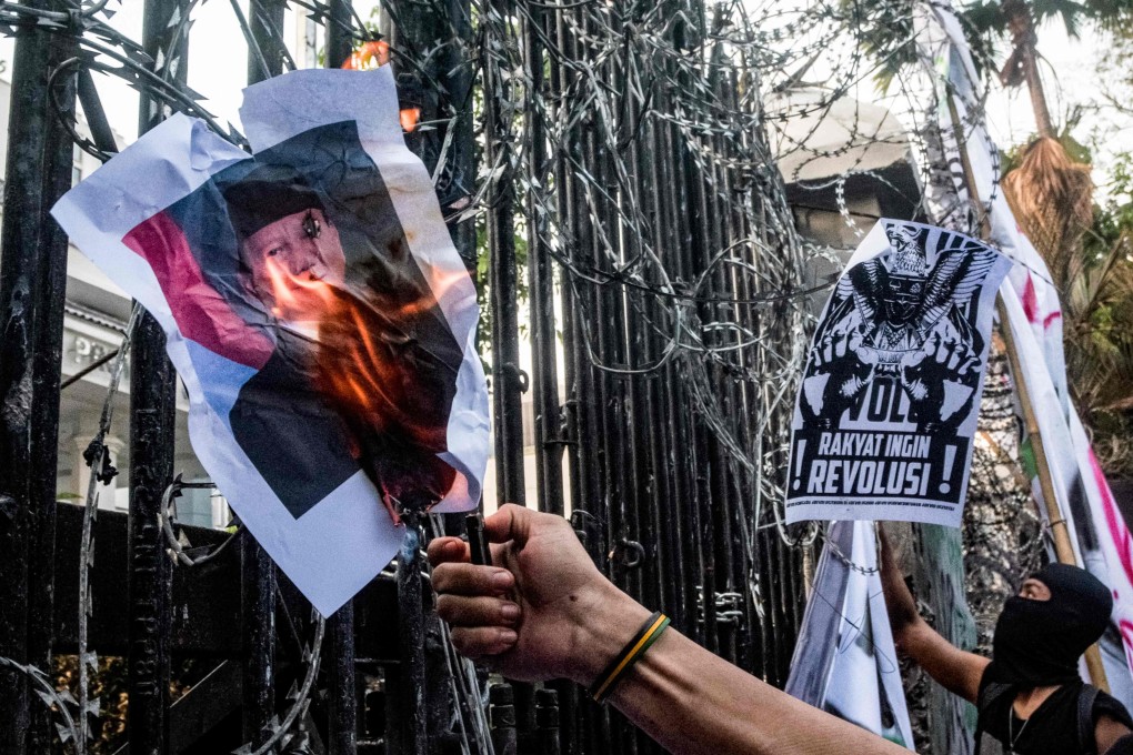 A demonstrator sets a picture of Indonesia’s President Prabowo Subianto on fire during a protest in Bandung, West Java, on Monday. Photo: AFP