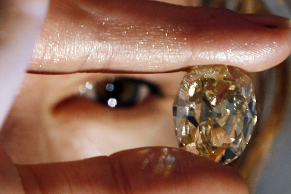 A model looks at a yellow 42.02 carat diamond at an auction show in Mumbai. Gem and jewellery exporters in India say they are seeing a sharp slowdown in new US orders due to a 50 per cent tariff on Indian exports. Photo: AFP
